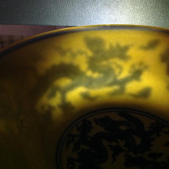 A Chinese yellow ground dragon and phoenix bowl, Xuande six character mark and possibly of the period, 19.5cm, museum restoration, sc